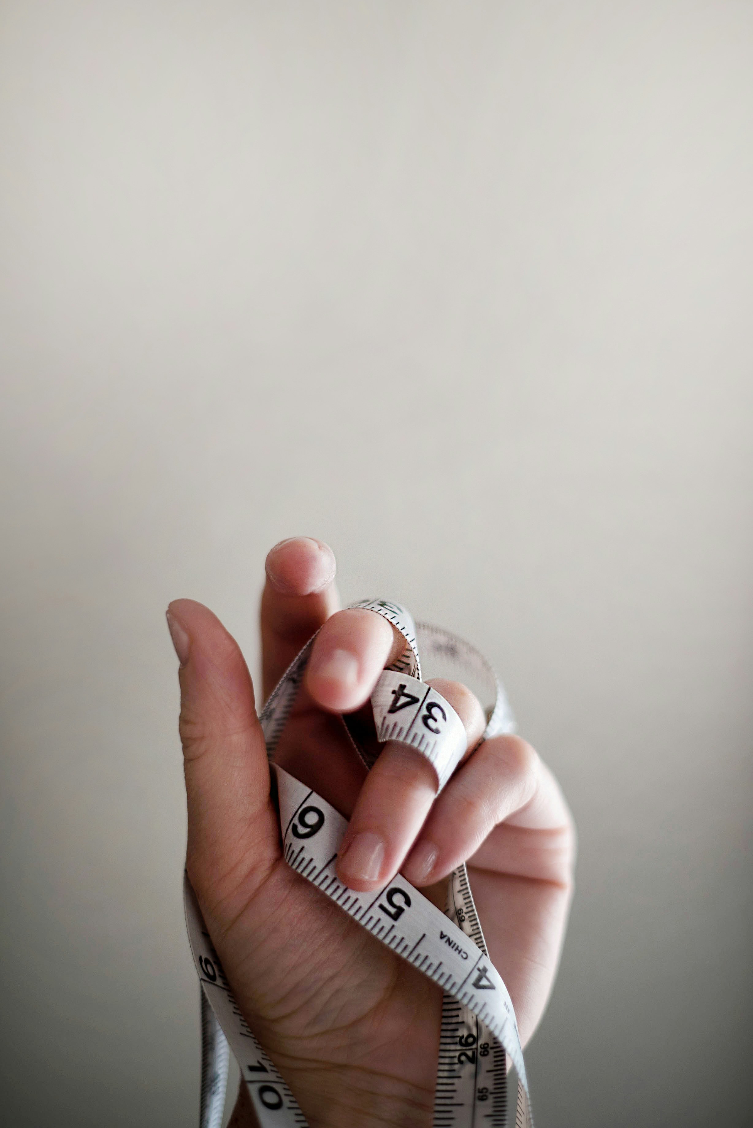 A hand holding a coiled tape measure